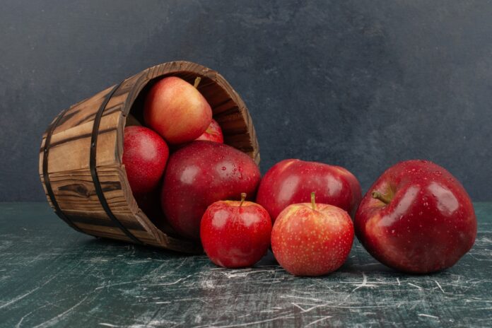 red-apples-falling-out-bucket-marble-table