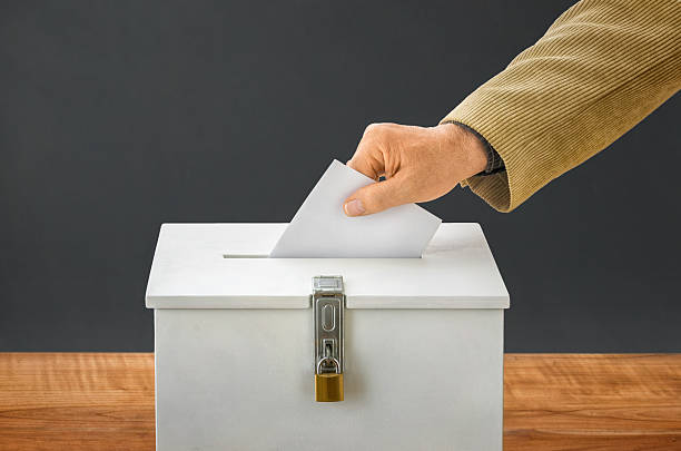 Man putting a ballot into a voting box